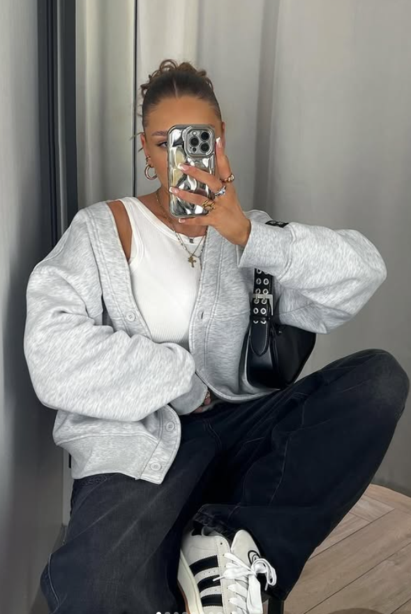 zipped grey sweatshirt, white top and black denim jeans and chunky sneakers